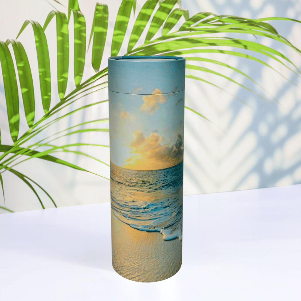 Scattering Tube with beach scene design on a white surface with green leaves in the background