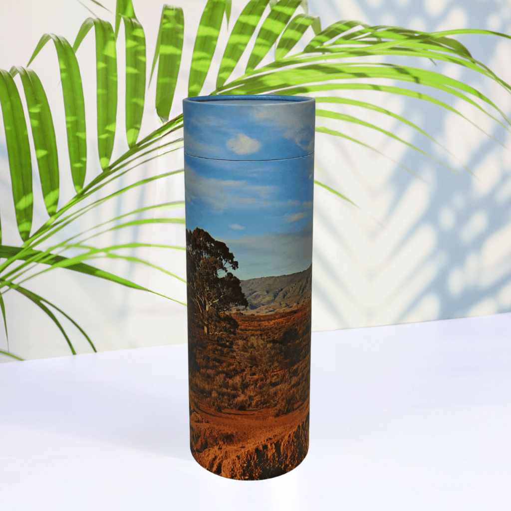 Scattering Tube with a landscape design on a white surface with green leaves in the background