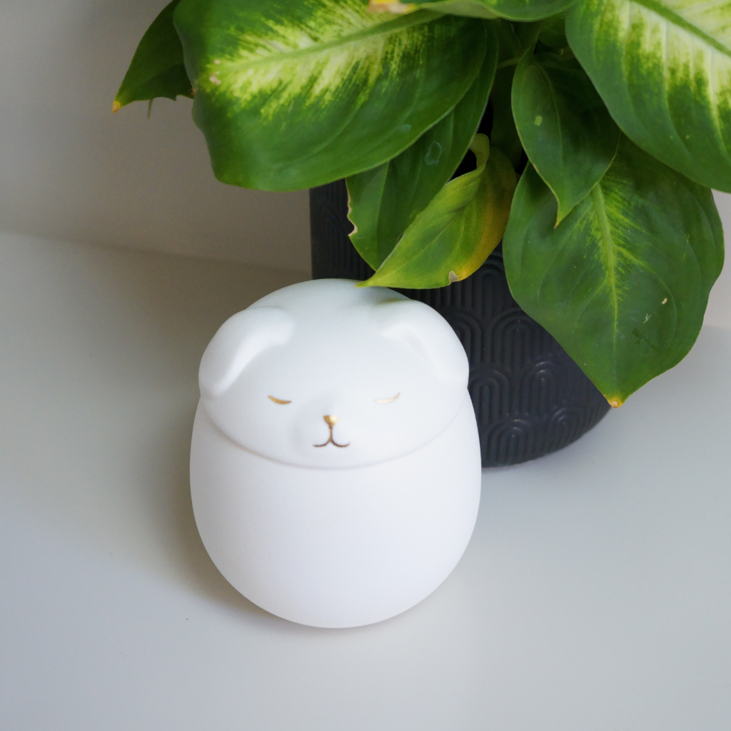 White canine companion ceramic urn in natural setting