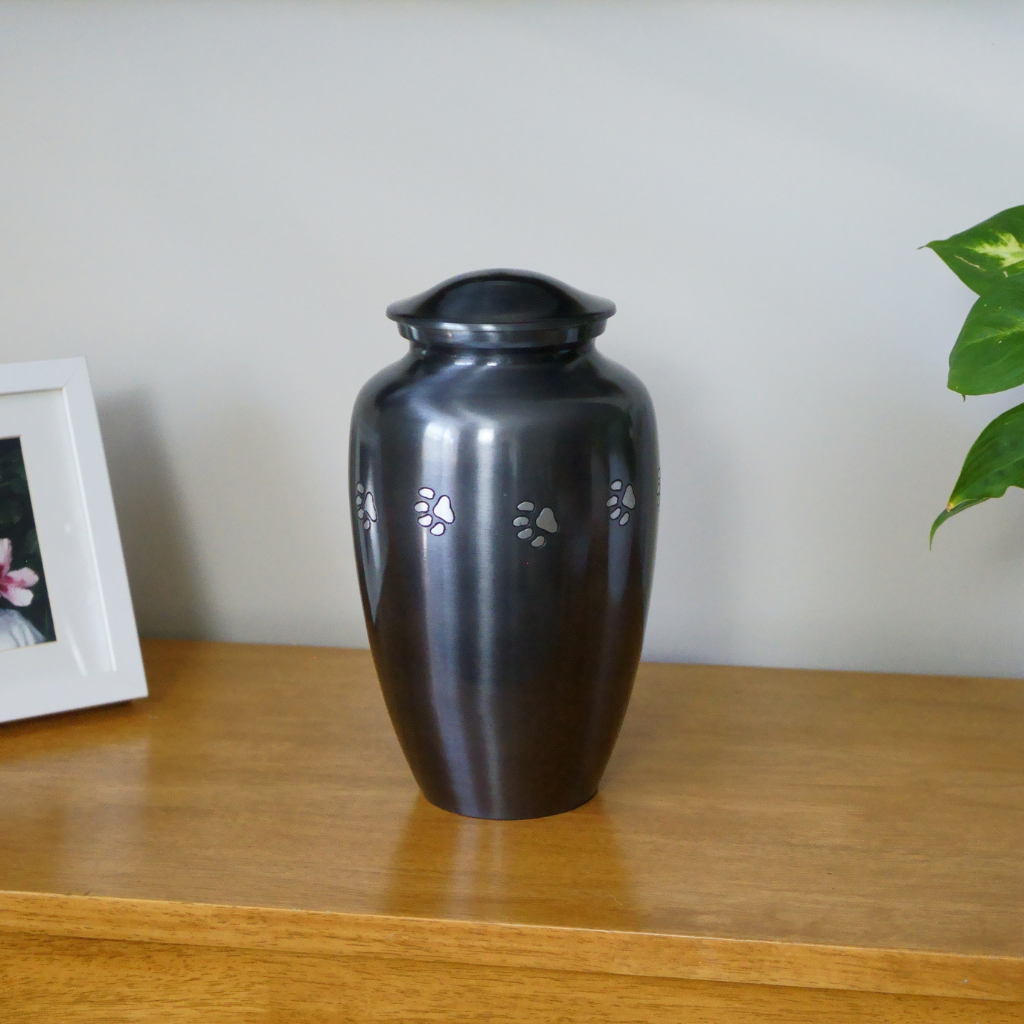Classic style silver urn with etched pawprints in natural setting