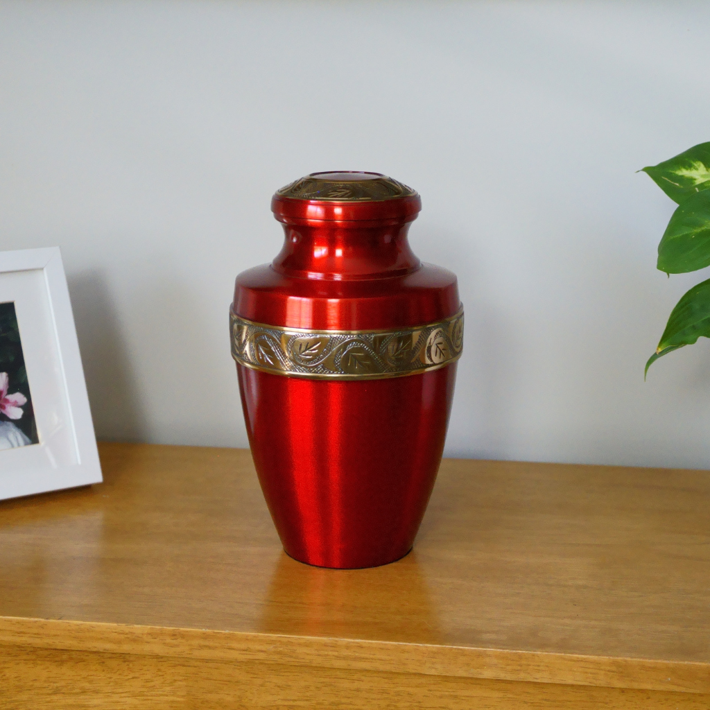 Red urn with with gold leaf details in natural setting