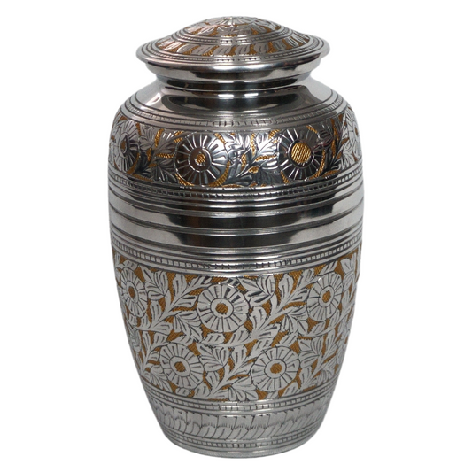 Silver and gold brass urn with intricate flower details 