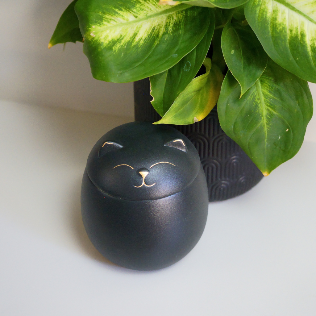 Black kitty comfort ceramic urn in natural setting