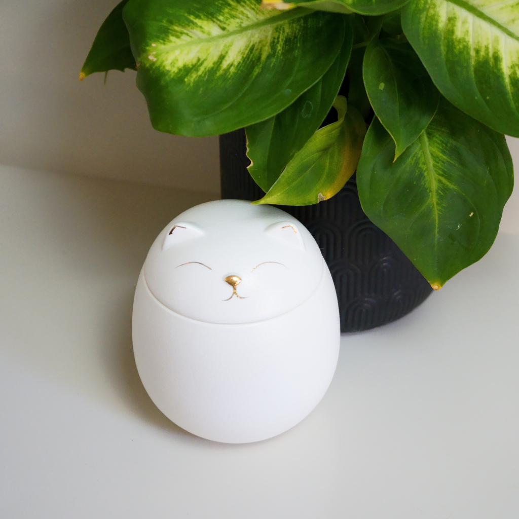 White kitty comfort ceramic urn in natural setting