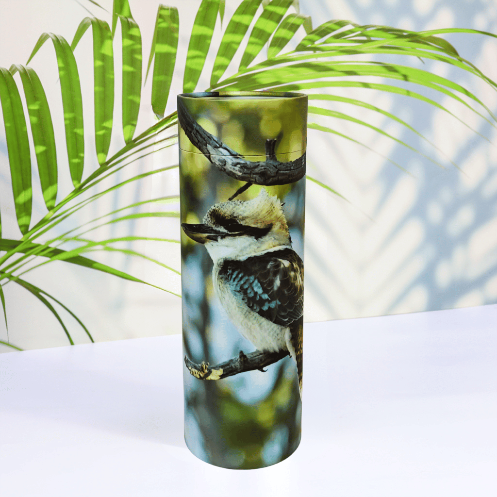 Scattering Tube with a kookaburra design on a white surface with green leaves in the background
