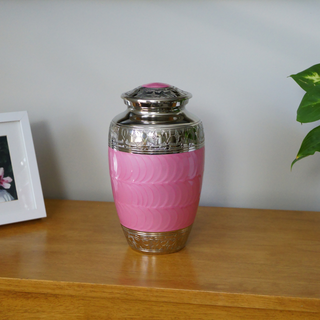 Pink wave textured urn with silver florentine detailing in natural setting