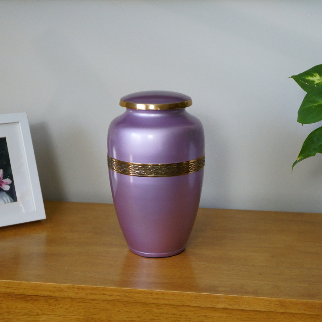 Pink urn with gold leaf details in natural setting
