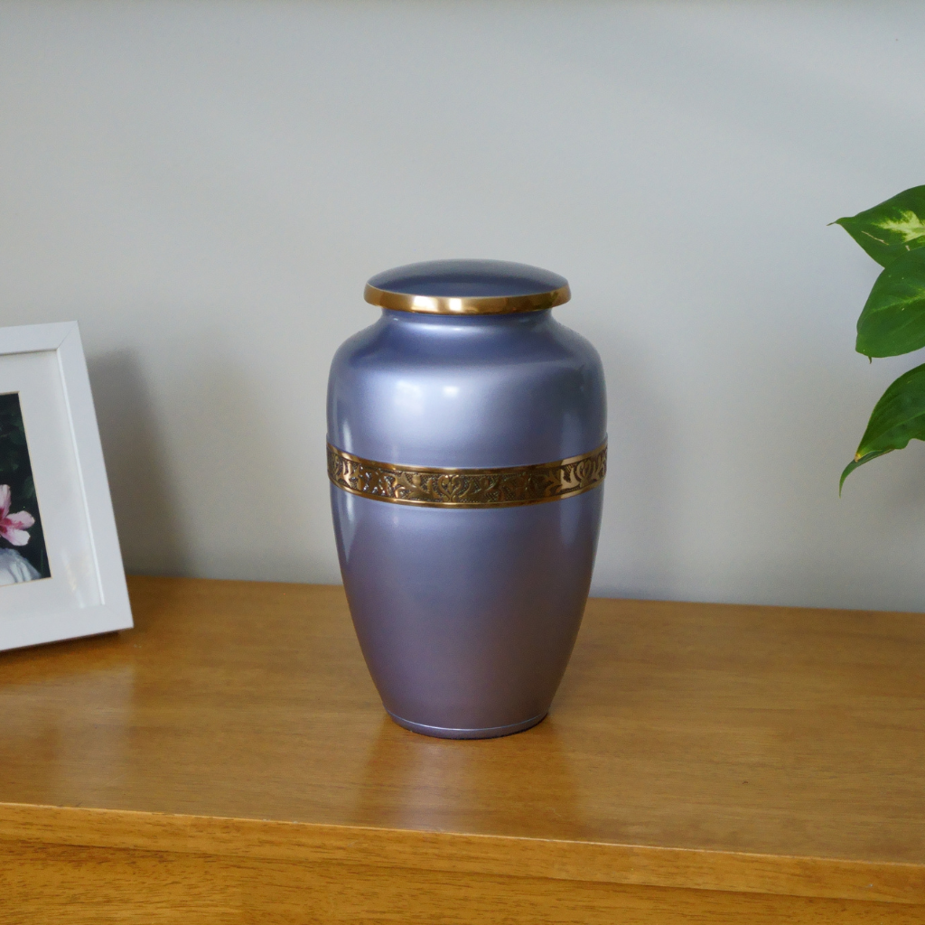 Silver bluish urn with gold leaf details in natural setting