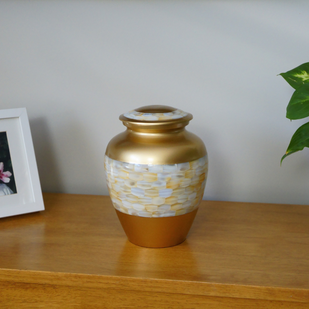 Gold urn with mother of pearl mosaic in natural setting