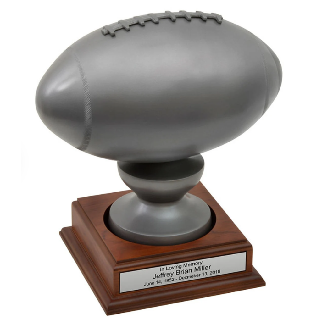 Silver rugby ball on wooden stand urn