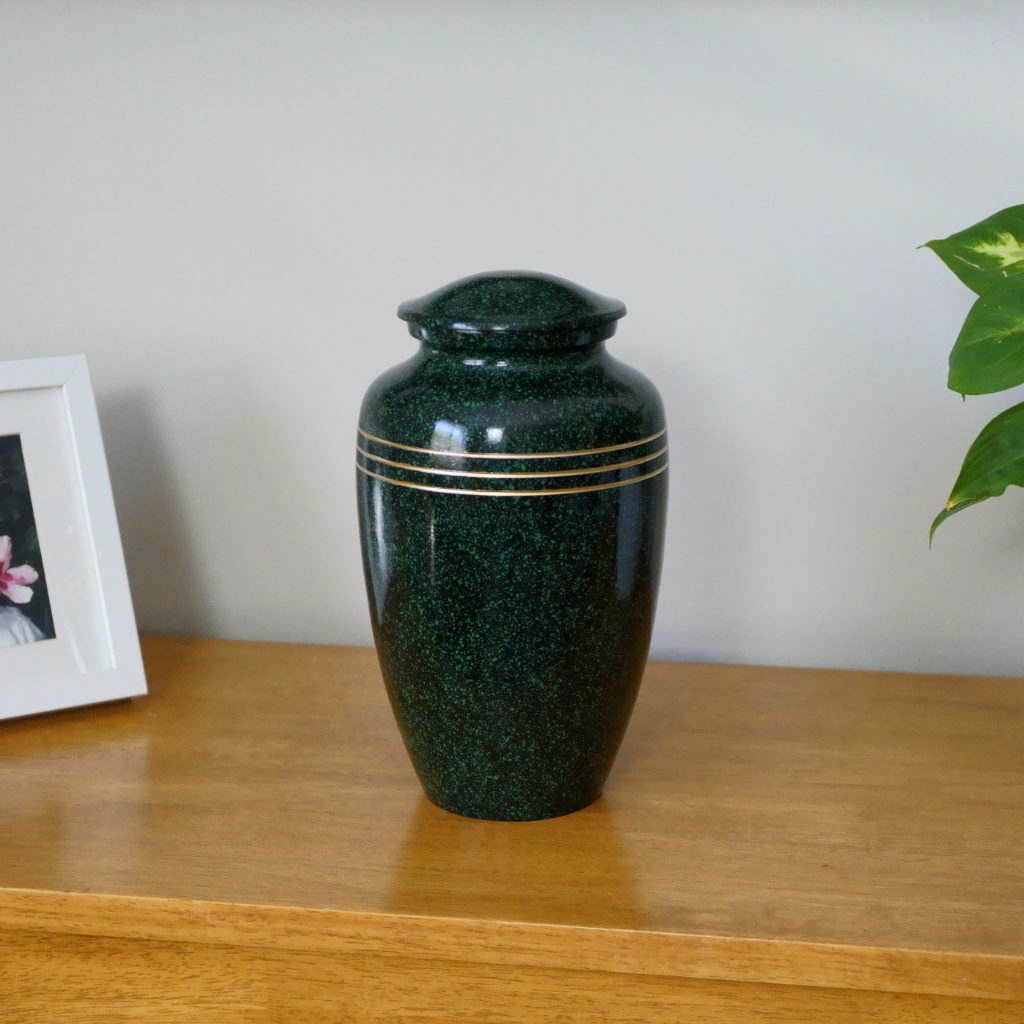 Sparkled green urn with 3 gold trim lines in natural setting