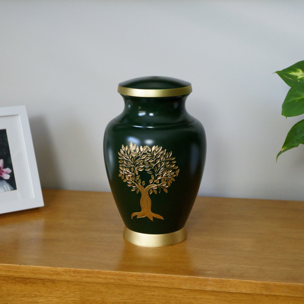 Green urn with gold tree of life image in natural setting